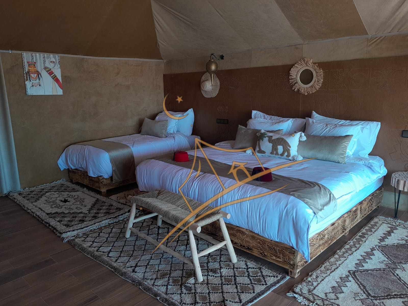 Sunlit tent bedroom with a hand-carved bed frame and Berber diamond-pattern rugs