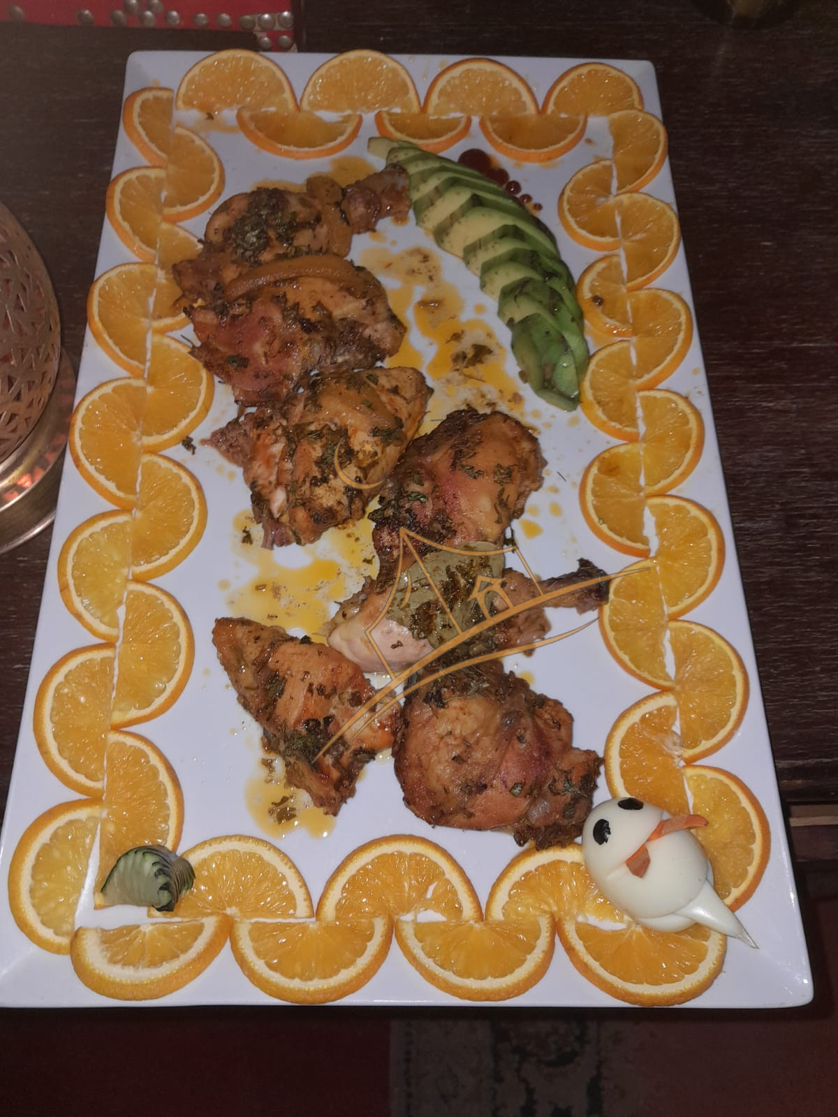 Herb-marinated grilled chicken framed by a border of fresh orange slices