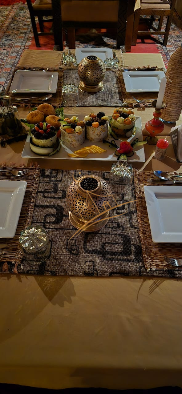Candlelit table set for two with a shared appetizer platter at Sahara Night Camp