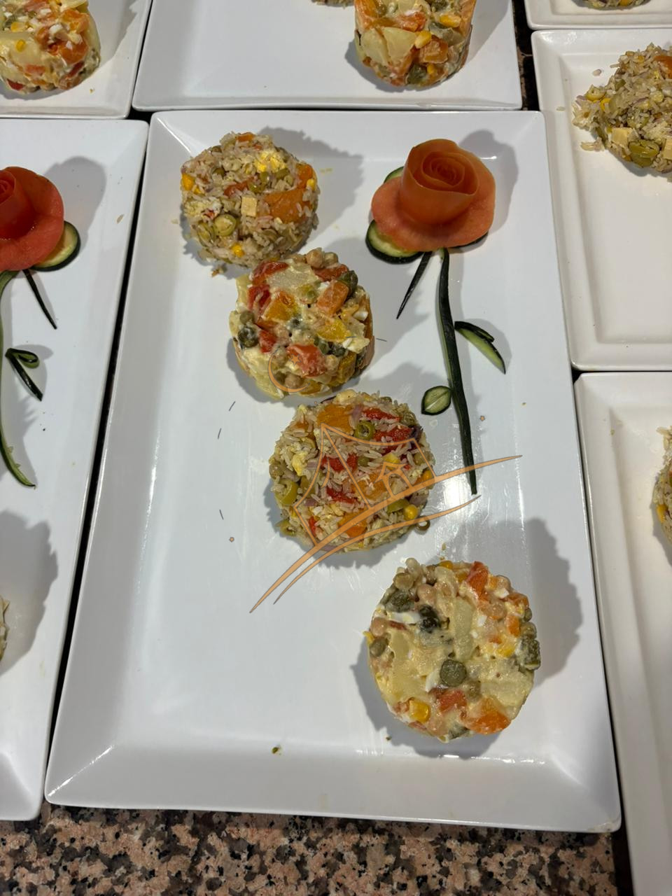 Rice and vegetable timbales garnished with a hand-carved tomato rose