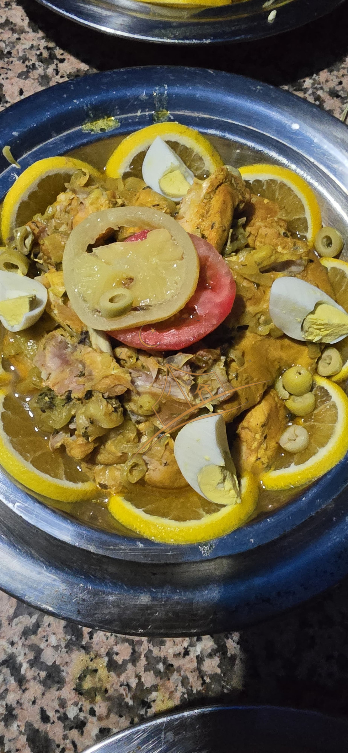 Traditional Moroccan chicken tagine garnished with preserved lemon, olives and egg
