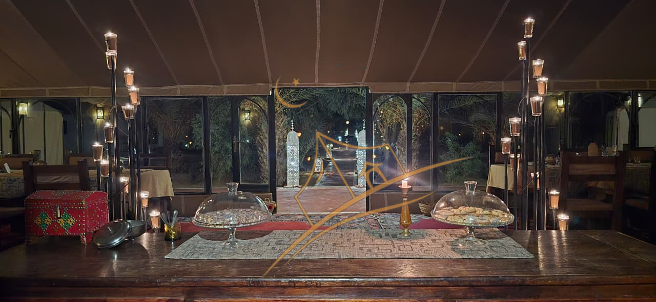 Candlelit dining tent buffet with an open doorway view to the palm-lined path outside